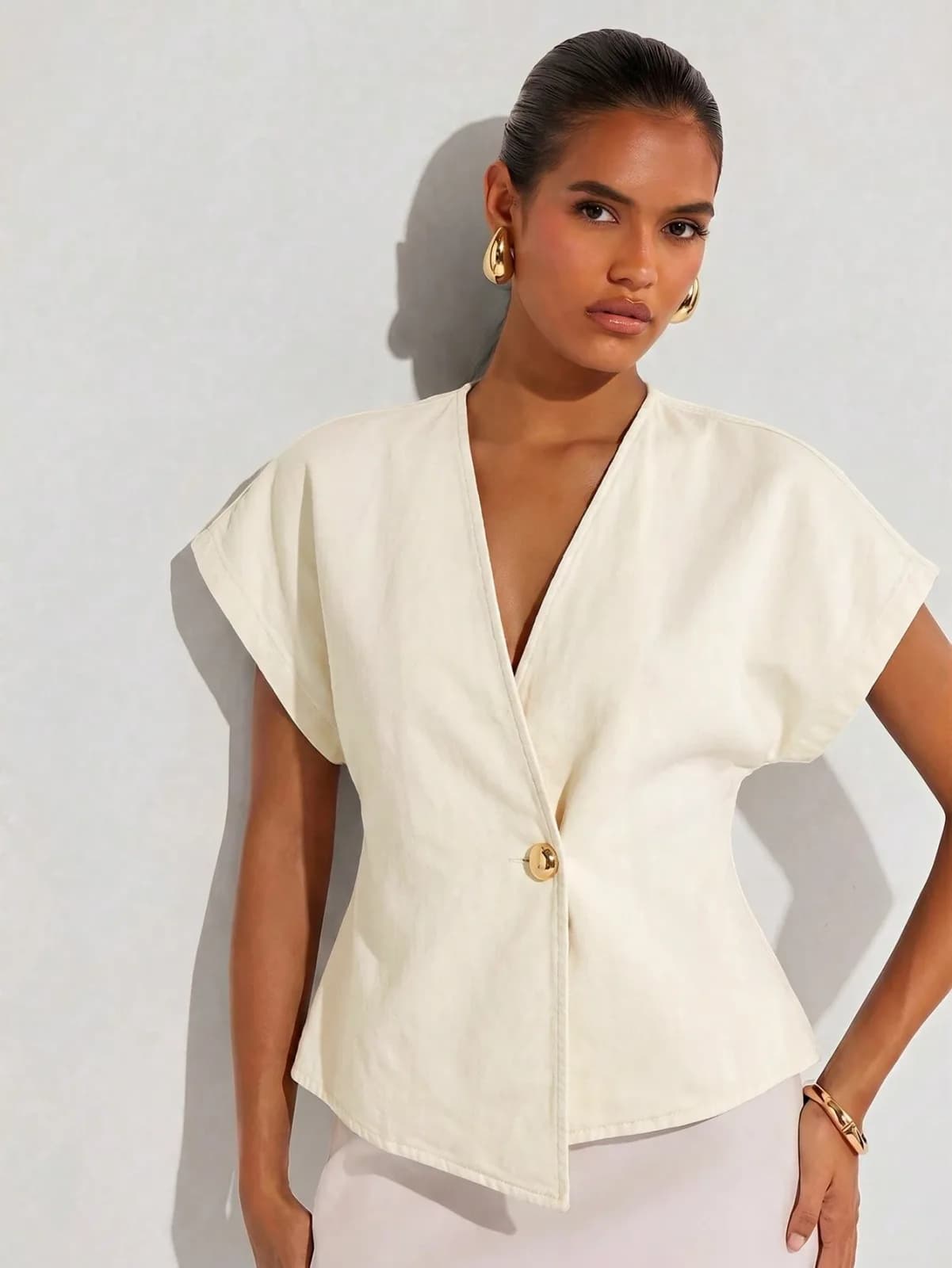 Blouse cache-cœur beige à manches courtes avec bouton doré