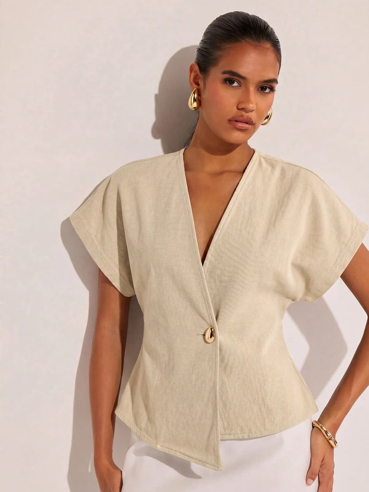 Blouse cache-cœur beige à manches courtes avec bouton doré